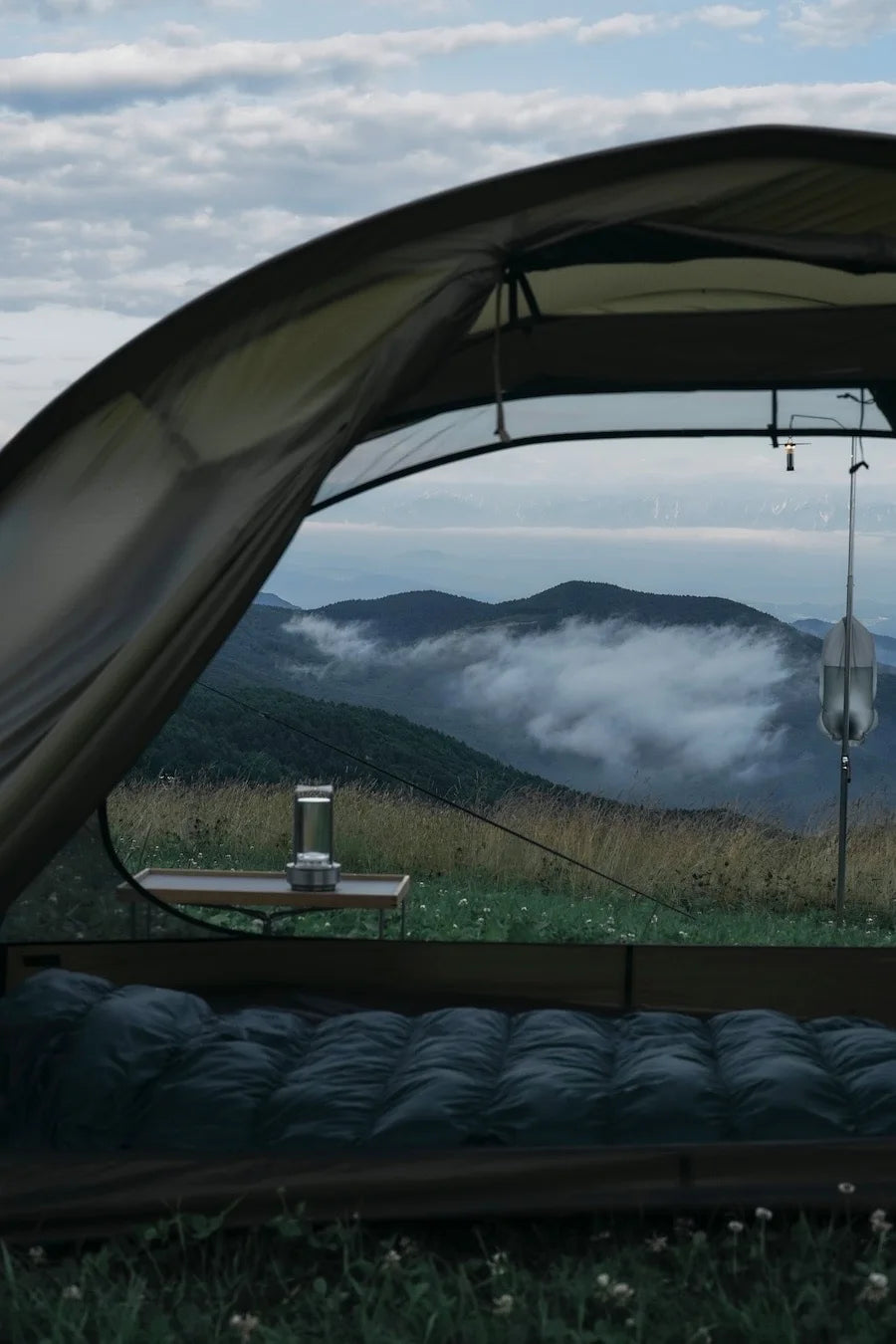 Camping scene with a tent overlooking misty mountains with broadcrate crystal lamp